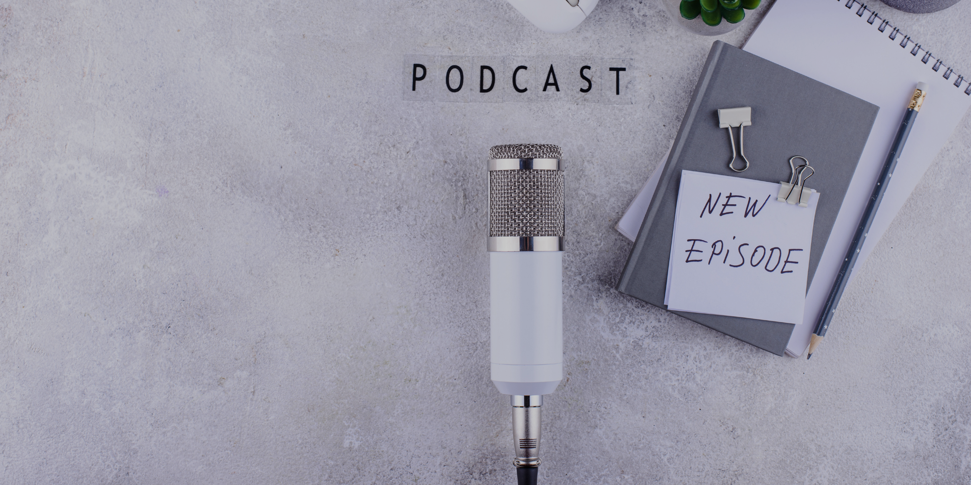 Podcast microphone beside a laptop, representing WedHQ conversations and episodes